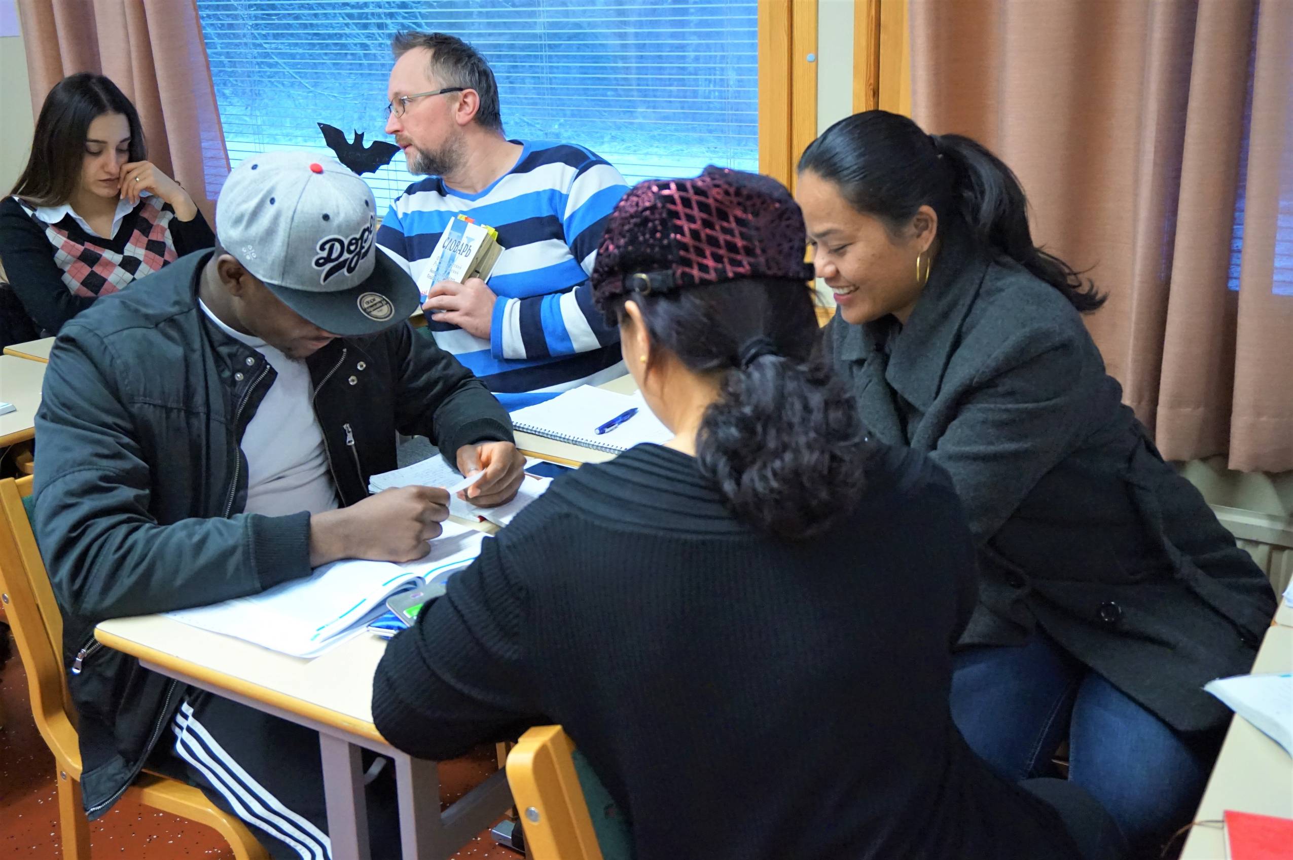 Opiskelijoita pöydän ääressä tekemässä tehtäviä yhdessä