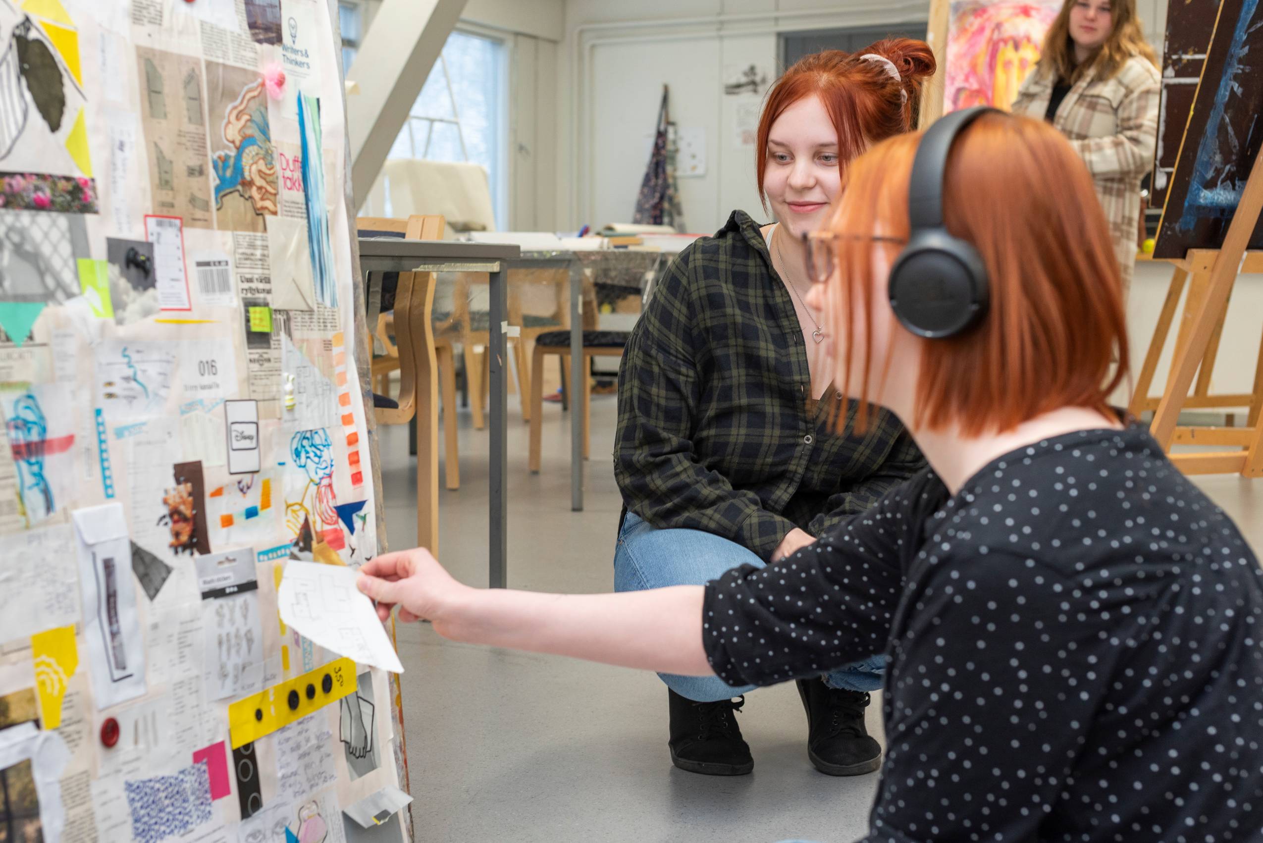 Kaksi opiskelijaa katsomassa toisen kuvataidetyötä