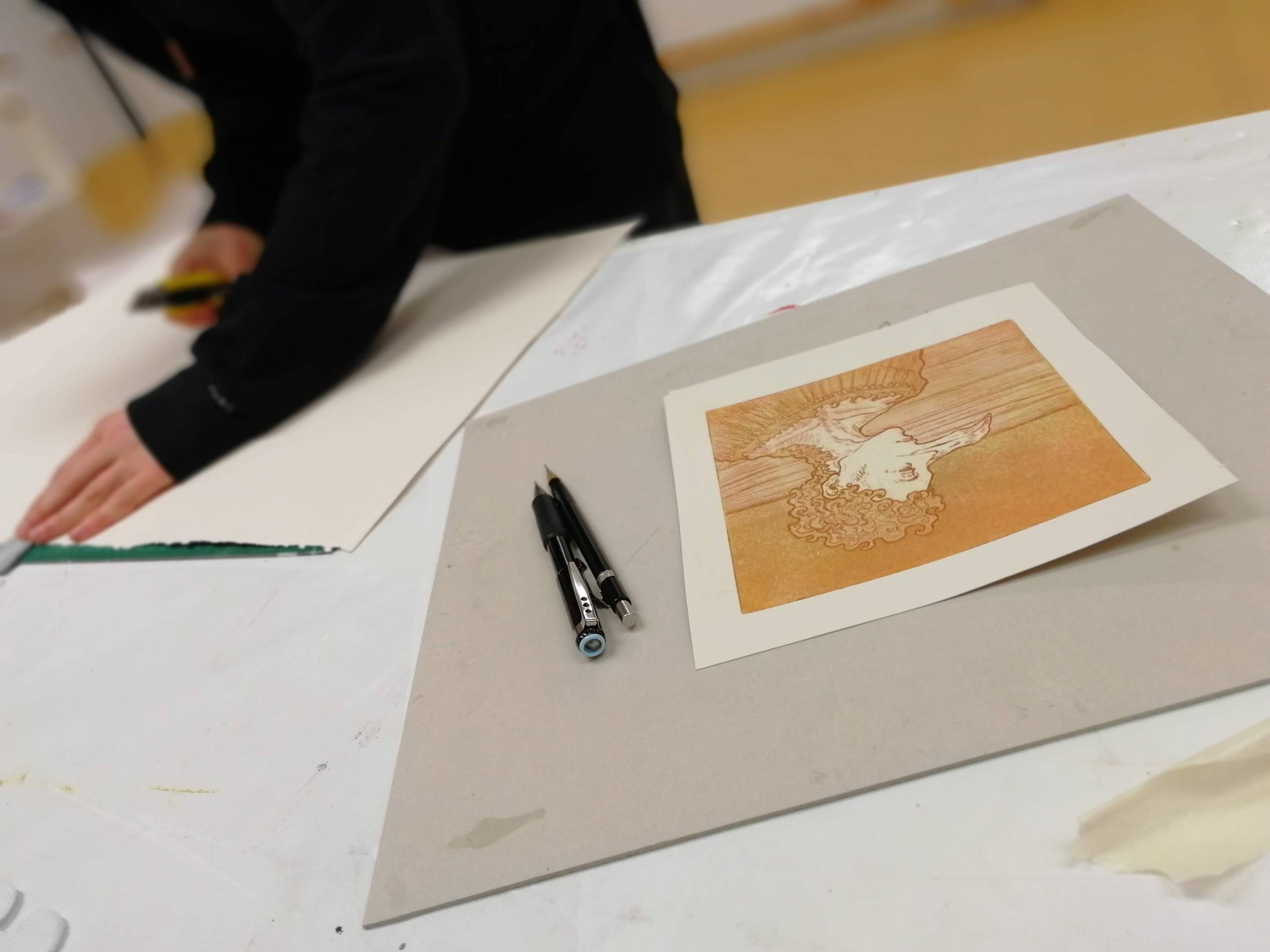 Lähikuva oranssin-rusehtavasta kuvataidetyöstä